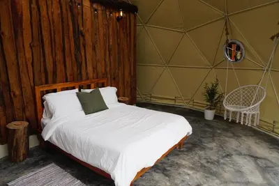 a bedroom with a bed in a tent at Nomad Dome at Salto Jimenoa Waterfall in Jarabacoa