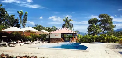 a pool with tables and chairs next to a resort at Colina Buena Vista A5 in Jarabacoa