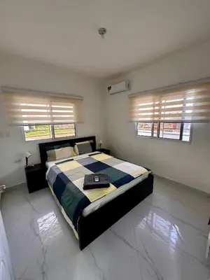 a bedroom with a bed in a room with windows at D&L Apartment in Bayahibe