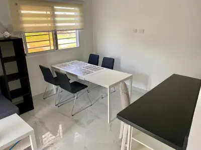 a dining room with a white table and chairs at D&L Apartment in Bayahibe