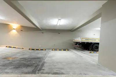 a large parking garage with a truck parked in it at Encantador Apto en Torre de Lujo, Piscina, AC & Parking in Santo Domingo