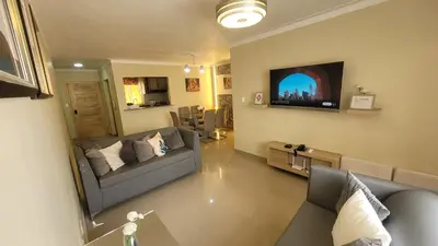 a living room with a couch and a tv at Apartamento Amaya in Licey