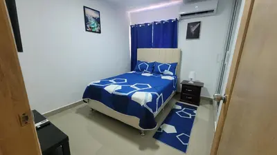 a bedroom with a blue and white bed in it at Apartamento Amaya in Licey