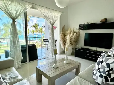 a living room with a television and a table with vases at Luxury 1 Bedroom with Seaview Seawinds in Cabarete