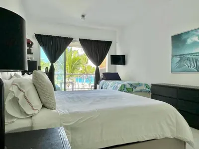 a bedroom with a large white bed and a balcony at Luxury 1 Bedroom with Seaview Seawinds in Cabarete