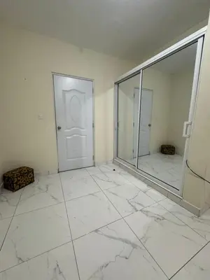 a white room with a mirror and a door at HEA Stays II in San Felipe de Puerto Plata