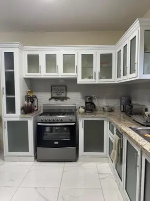 a kitchen with white cabinets and a stove at HEA Stays II in San Felipe de Puerto Plata