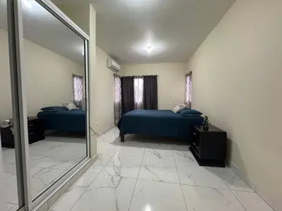a bedroom with two beds and a large mirror at HEA Stays II in San Felipe de Puerto Plata