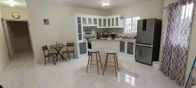 a kitchen with a refrigerator and a table and chairs at HEA Stays II in San Felipe de Puerto Plata