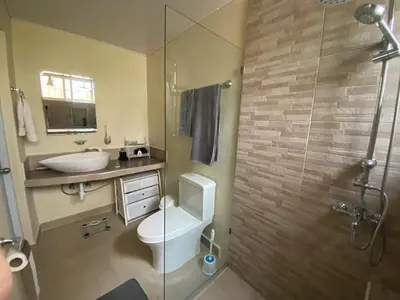 a bathroom with a toilet and a sink and a shower at 2BR & 2 WR ocean view Suite at Villa Costa Verde in Playa Cofresi, Puerto Plata, with a pool, big veranda, and a rooftop terrace in San Felipe de Puerto Plata