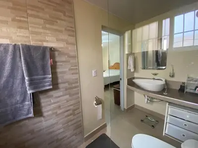 a bathroom with a sink and a toilet and a mirror at 2BR & 2 WR ocean view Suite at Villa Costa Verde in Playa Cofresi, Puerto Plata, with a pool, big veranda, and a rooftop terrace in San Felipe de Puerto Plata