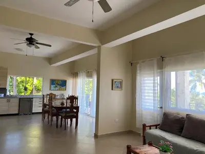 a living room with a couch and a table at 2BR & 2 WR ocean view Suite at Villa Costa Verde in Playa Cofresi, Puerto Plata, with a pool, big veranda, and a rooftop terrace in San Felipe de Puerto Plata