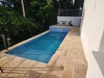 a swimming pool on a patio with a table and chairs at Villas Montemar - Villa Mar in Las Terrenas