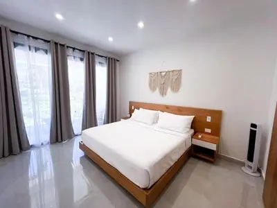 a bedroom with a large bed in a room with windows at Villas Montemar - Villa Mar in Las Terrenas