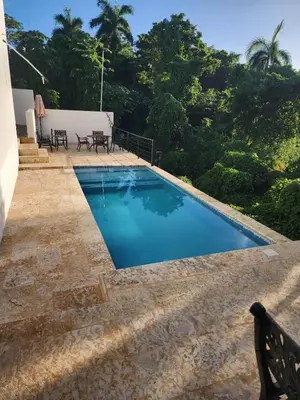 a swimming pool with chairs and trees in the background at Villas Montemar - Villa Mar in Las Terrenas