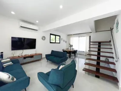 a living room with blue couches and a tv at Villas Montemar - Villa Sol in Las Terrenas