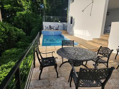 a patio with a table and chairs and a pool at Villas Montemar - Villa Sol in Las Terrenas