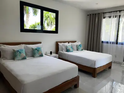 a bedroom with two beds and a window at Villas Montemar - Villa Sol in Las Terrenas