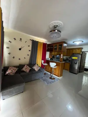a living room with a couch and a clock on the wall at Hogar lejos de casa, piscina in San Cristóbal