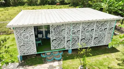 a small white house with a metal roof at BlueEcolandia Bungalow AGUA in Jarabacoa