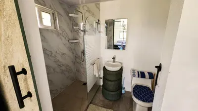 a bathroom with a shower and a toilet and a sink at BlueEcolandia Bungalow AGUA in Jarabacoa