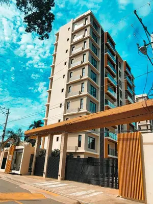 a tall white apartment building with a building at Apartamento moderno 3H en TREO zona metropolitana in Santiago de los Caballeros