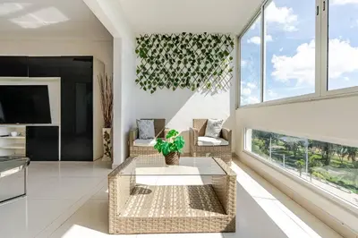 a living room with wicker chairs and a table at Luxury Ocean View Condo in Santo Domingo in La Francia