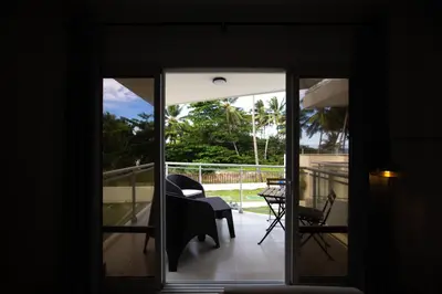 a glass door leading to a balcony with a chair at CMB202 BEACH AREA Res Cristamar in Eslabón