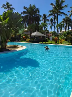 a person swimming in a large blue swimming pool at Appartement Paraiso 150m playa ballenas in Las Terrenas