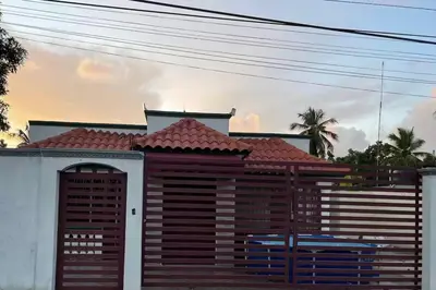 a house with a wooden fence in front of it at Alojamiento cómodo en Boca chica in Santo Domingo