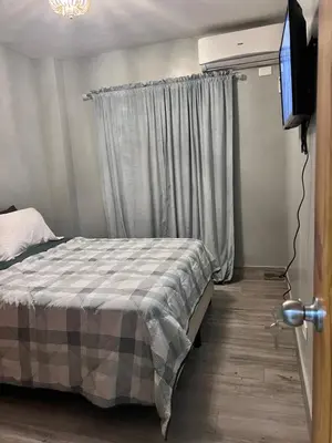 a bedroom with a bed and a flat screen tv at Cozy Retreat 1st Floor in Arenoso
