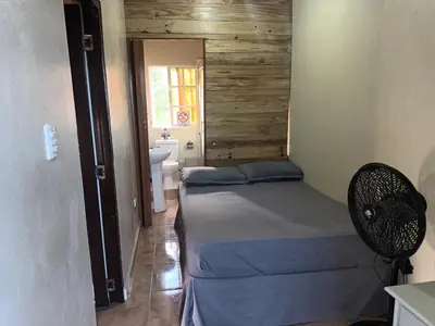 a small bedroom with a bed and a bathroom at Habitación Taina in Jarabacoa