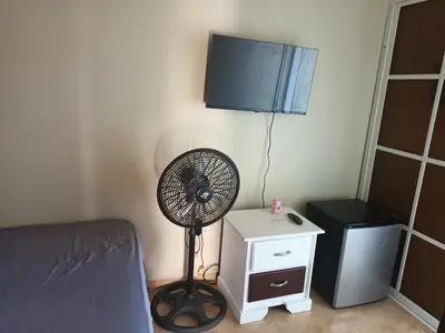 a bedroom with a fan next to a bed at Habitación Taina in Jarabacoa