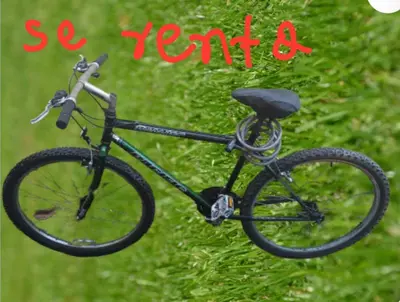 a black bike is hanging on the grass at Habitación Taina in Jarabacoa