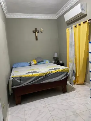 a bedroom with a bed with a cross on the wall at Rancho silvestre in Monte Plata