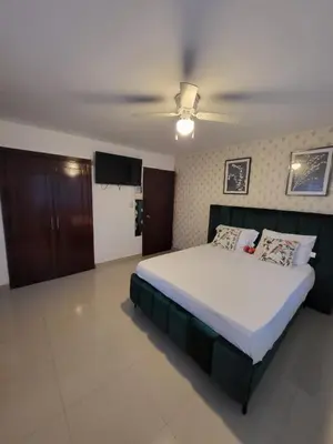 a bedroom with a bed and a ceiling fan at Santuario Tropical at Marino Paradise in La Puntica de Juan Dolio