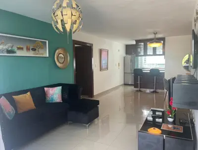 a living room with a black couch and a blue wall at Santuario Tropical at Marino Paradise in La Puntica de Juan Dolio