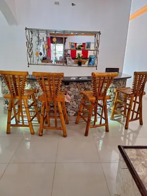 a group of wooden chairs and a bar at Casa Rural con Piscina in Azua de Compostela