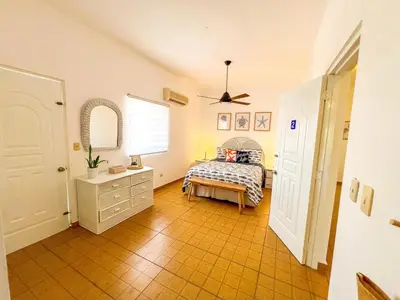 a bedroom with a bed and a dresser and a window at Villa Cruz in Las Galeras