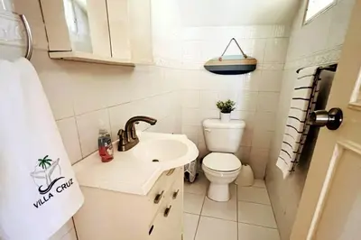 a small bathroom with a toilet and a sink at Villa Cruz in Las Galeras