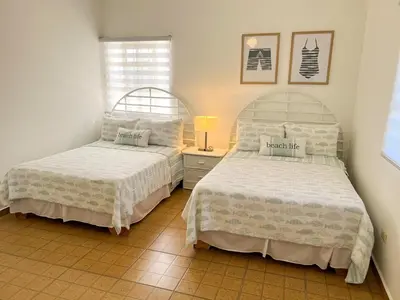 a bedroom with two beds and a lamp on a tiled floor at Villa Cruz in Las Galeras
