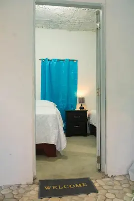a bedroom with a bed and a blue shower curtain at Hotel-Restaurante Snack Cana in La Ciénaga