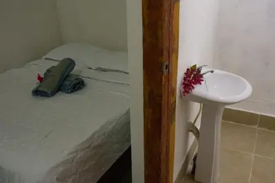 a bedroom with a bed and a sink next to at Hotel-Restaurante Snack Cana in La Ciénaga