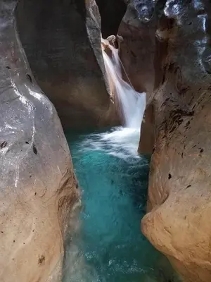 a waterfall in a pool of water between two rocks at Hotel-Restaurante Snack Cana in La Ciénaga