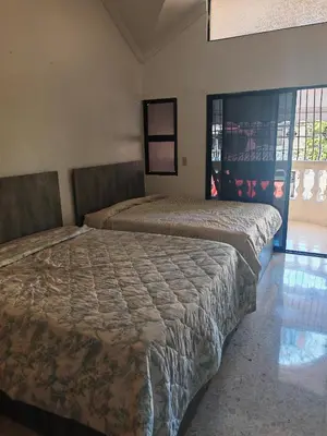 two beds sitting in a room with a window at Habitación cuádruple Casa Grande Corales del Sur in La Viva