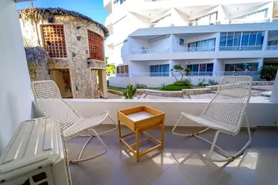 a balcony with chairs and a table and a building at OCEANPARADISE to you ALBATRO l Y ll in Juan Dolio