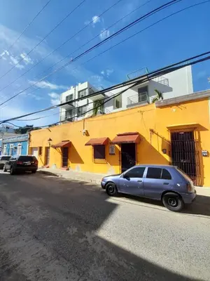 a blue car parked in front of a yellow building at Fantastic with Terrace in the colonial zone in Santo Domingo