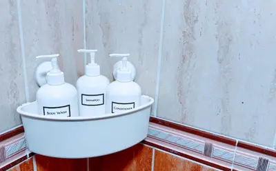 three white bottles in a bucket next to a wall at Walk to Beach, Shops, Dining, Pool View, Fast Wifi in Punta Cana