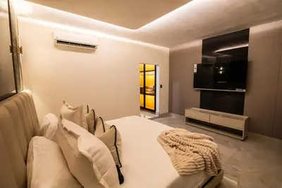 a living room with a bed and a television at lovera hotel in Santiago de los Caballeros