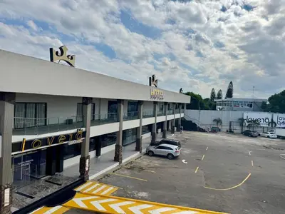 a car parked in a parking lot in front of a building at lovera hotel in Santiago de los Caballeros